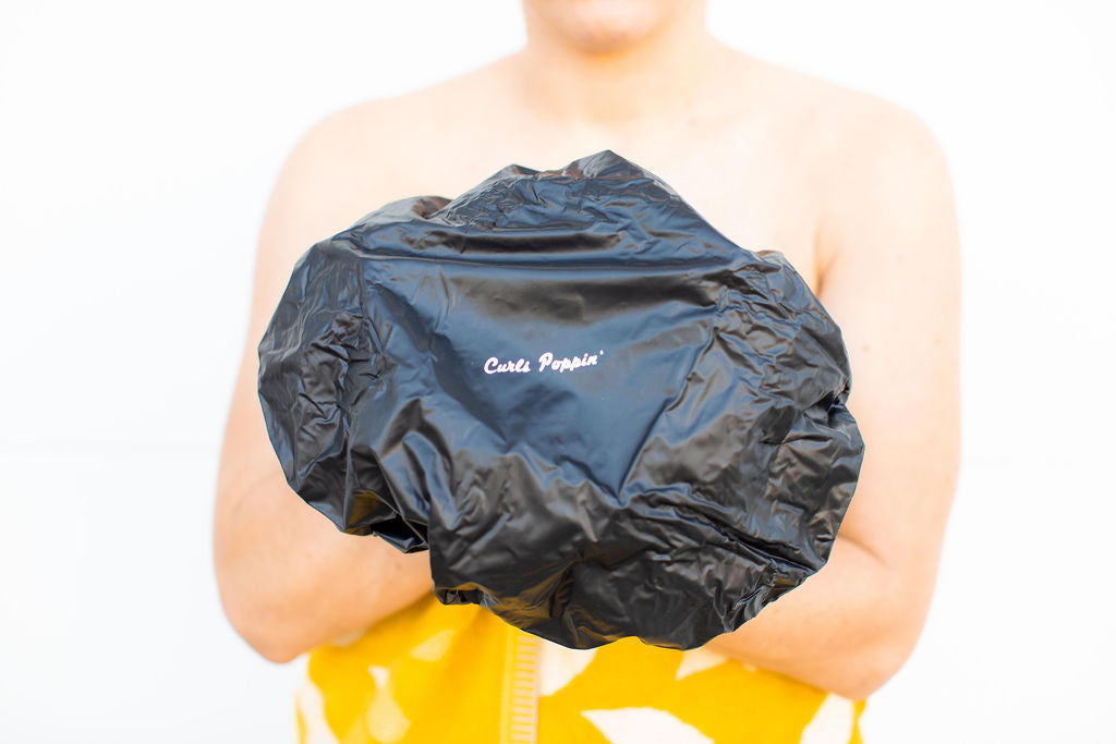 a lady using a satin shower cap for curly hair